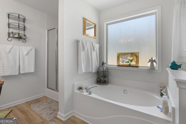 bathroom with plus walk in shower and wood-type flooring