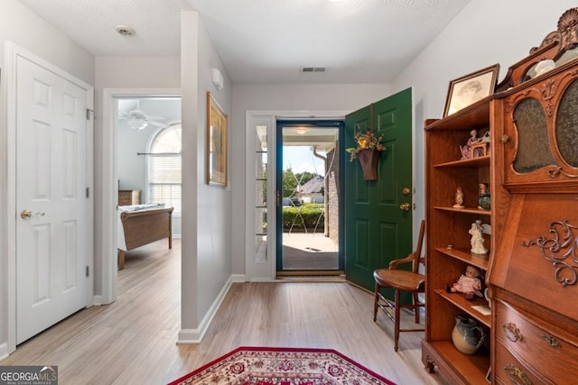 foyer entrance with plenty of natural light, light hardwood / wood-style floors, a textured ceiling, and ceiling fan