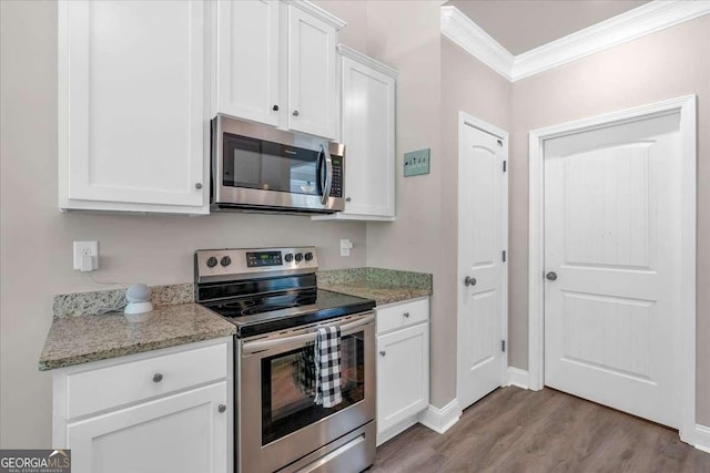 kitchen with light stone countertops, appliances with stainless steel finishes, ornamental molding, light hardwood / wood-style flooring, and white cabinets