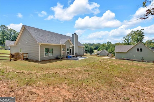 back of house with a patio area and a yard