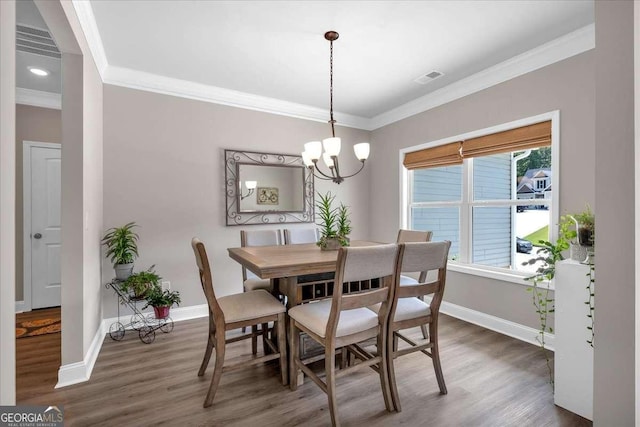 dining area featuring a chandelier, dark hardwood / wood-style flooring, and ornamental molding