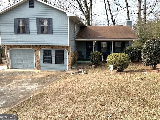 split level home with covered porch and a garage