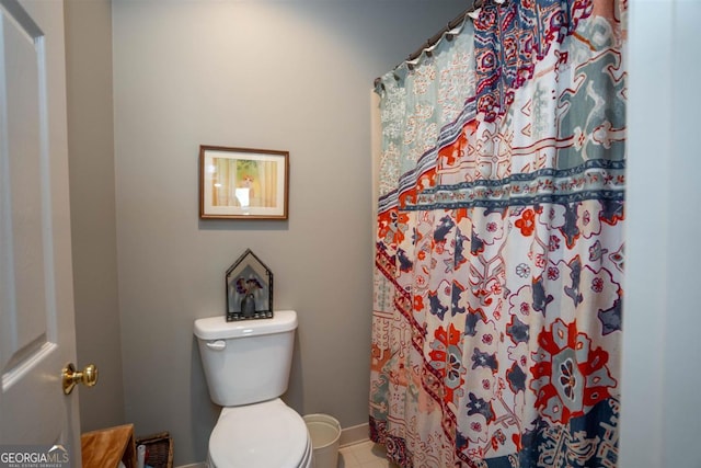 bathroom with tile patterned floors, a shower with curtain, and toilet