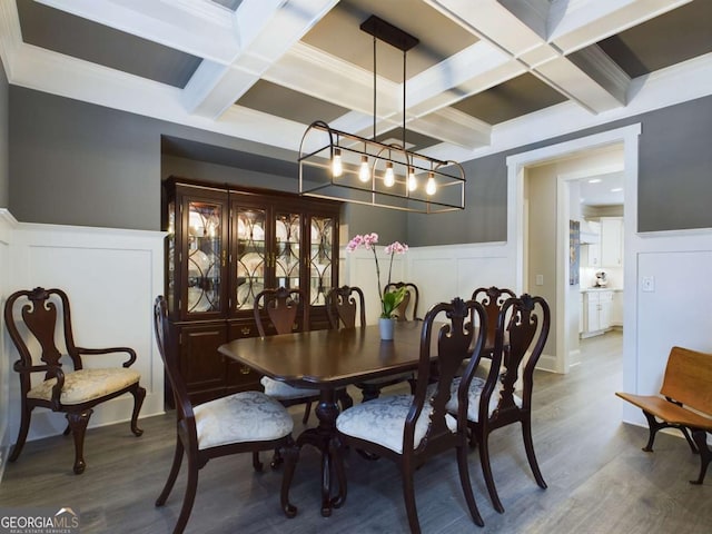 dining space featuring beam ceiling, ornamental molding, coffered ceiling, and hardwood / wood-style floors