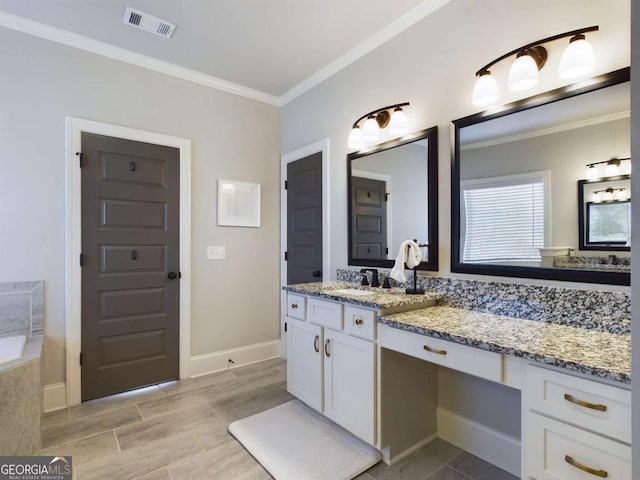 bathroom with vanity, crown molding, and tiled bath