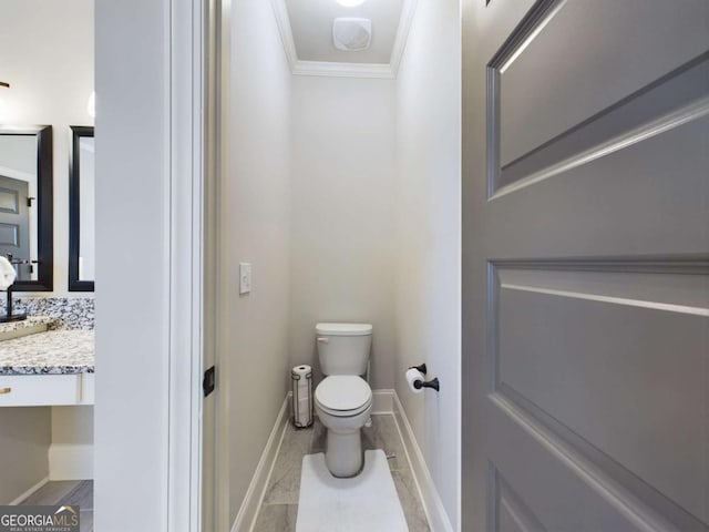 bathroom with decorative backsplash, toilet, ornamental molding, and vanity