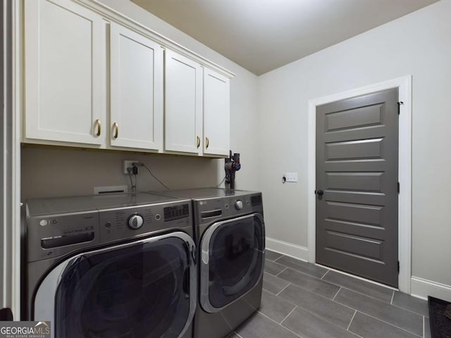 washroom with washer and dryer and cabinets