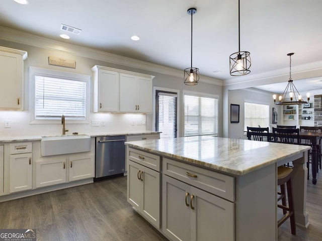 kitchen featuring white cabinets, sink, decorative light fixtures, dishwasher, and a center island