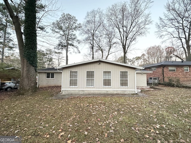 rear view of house featuring a yard