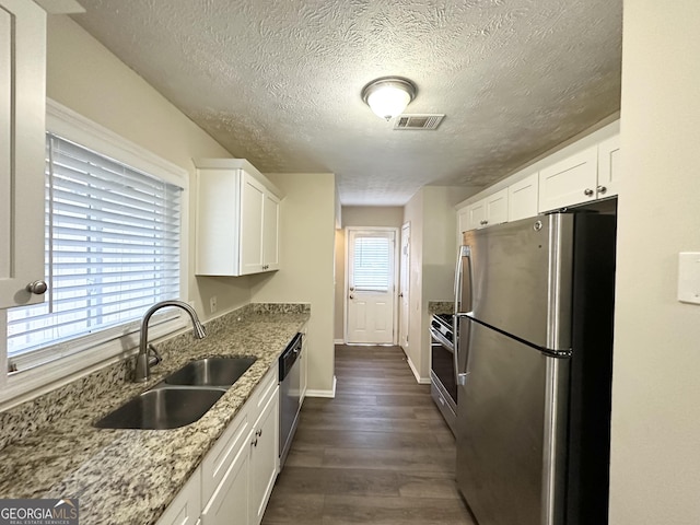 kitchen featuring light stone countertops, stainless steel appliances, white cabinetry, and sink