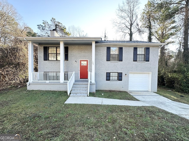 bi-level home featuring a front yard, a porch, and a garage