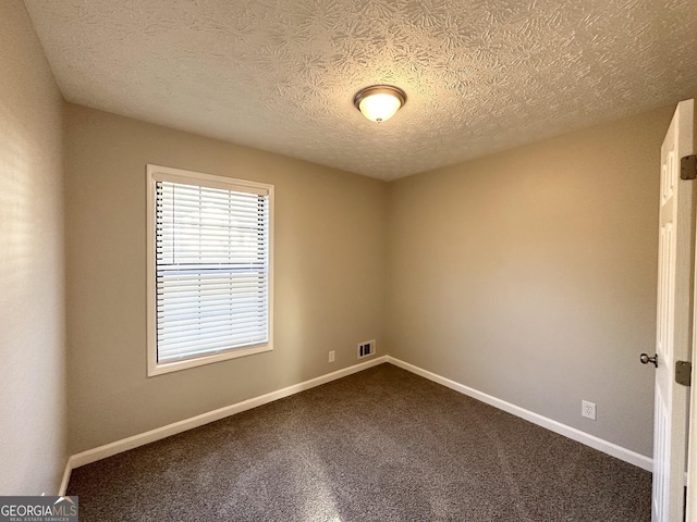 carpeted spare room with a textured ceiling