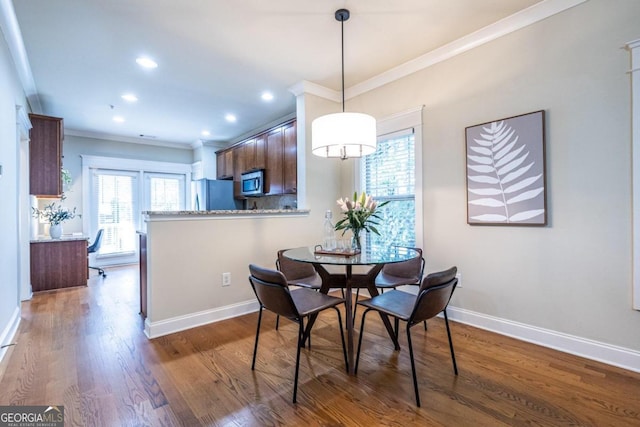 dining area featuring dark hardwood / wood-style flooring and ornamental molding