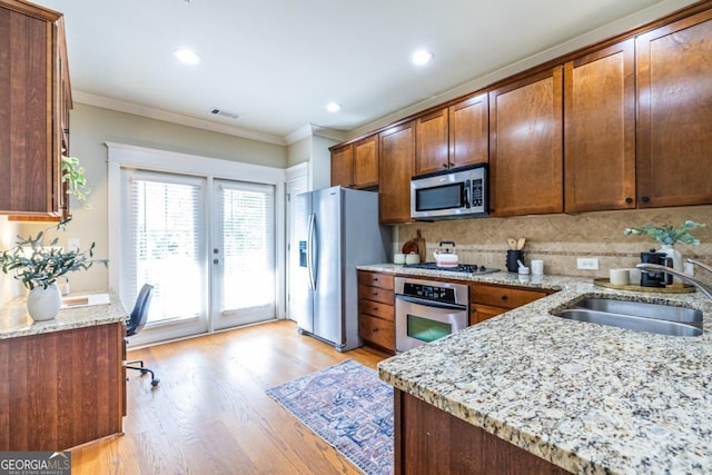 kitchen featuring french doors, sink, ornamental molding, light stone countertops, and appliances with stainless steel finishes