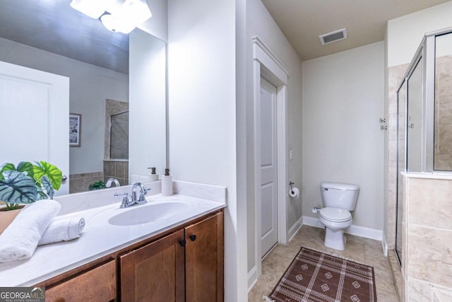 bathroom with vanity, toilet, and a shower with door