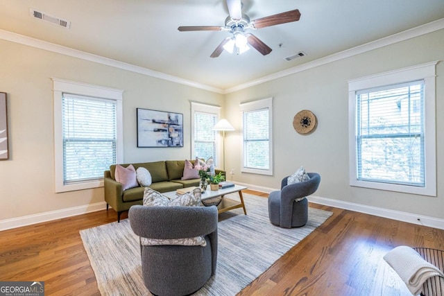 living room with hardwood / wood-style flooring, ceiling fan, and crown molding