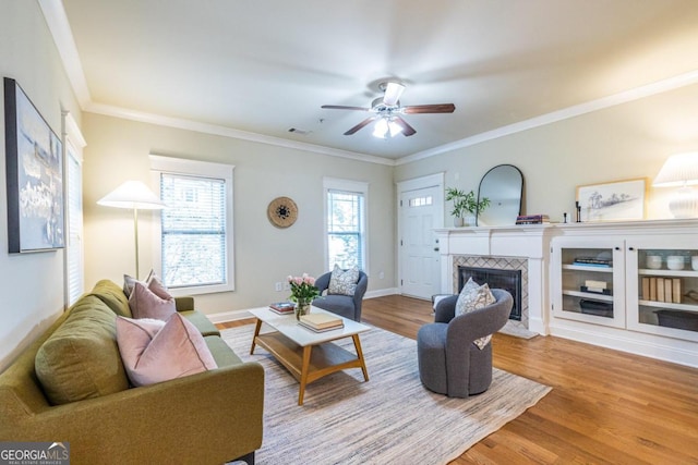 living room with hardwood / wood-style flooring, a fireplace, and crown molding