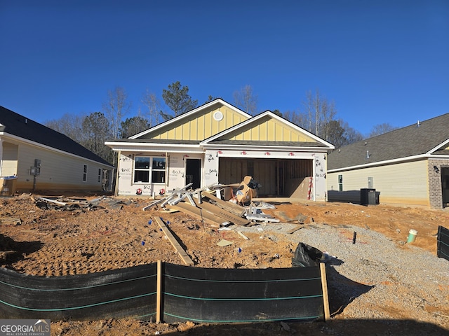 property under construction with board and batten siding, an attached garage, and central air condition unit