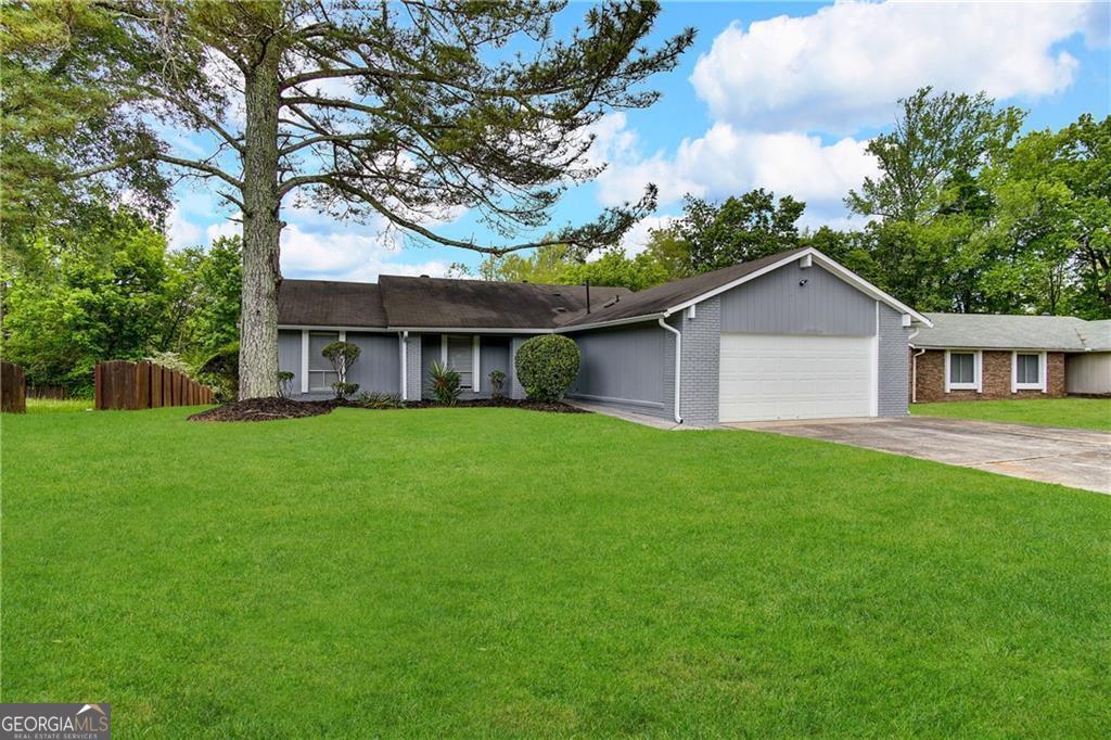 single story home with a front yard and a garage