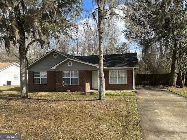 ranch-style home featuring central AC, brick siding, a front yard, and driveway