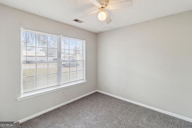 carpeted empty room with visible vents, a textured ceiling, and baseboards