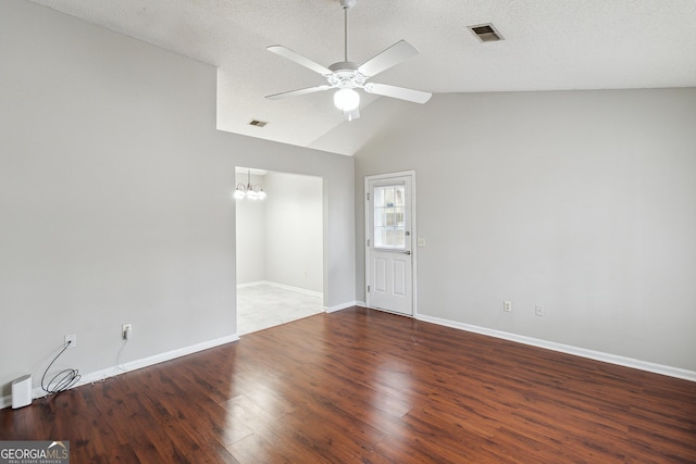 spare room with ceiling fan with notable chandelier, a textured ceiling, dark hardwood / wood-style flooring, and lofted ceiling