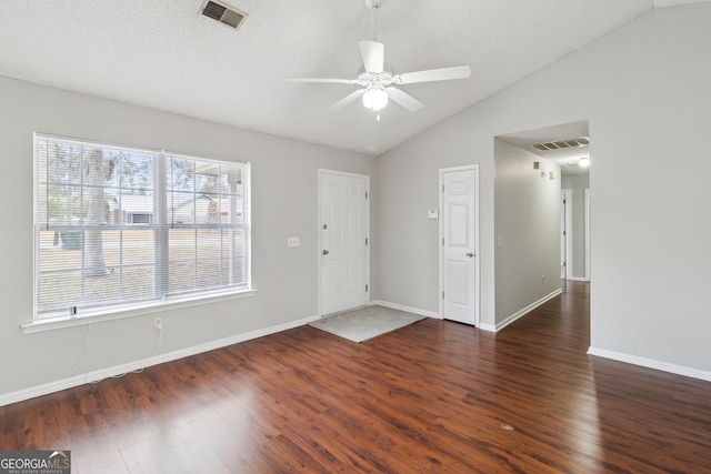 interior space featuring lofted ceiling, visible vents, dark wood finished floors, and ceiling fan