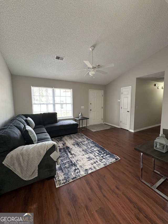 interior space featuring lofted ceiling, visible vents, dark wood finished floors, and ceiling fan