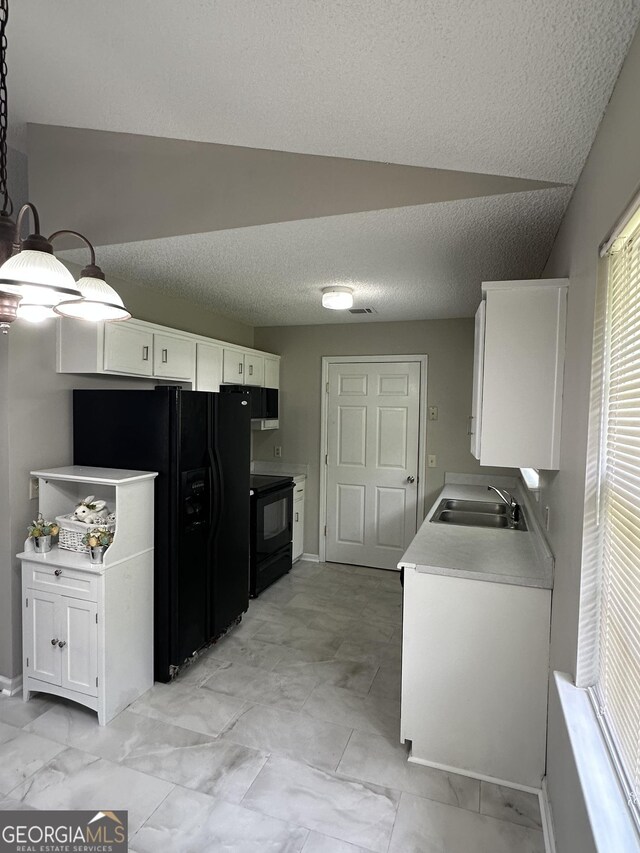 kitchen featuring black appliances, a sink, light countertops, and white cabinetry