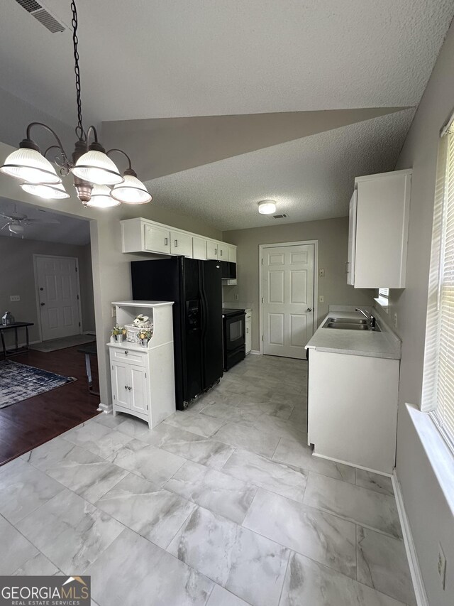 kitchen featuring white cabinets, light countertops, a sink, and black appliances