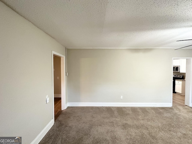 empty room with ceiling fan, carpet, and a textured ceiling