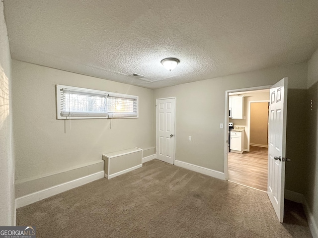 unfurnished bedroom featuring carpet flooring and a textured ceiling