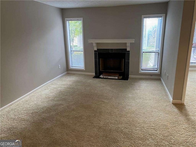 unfurnished living room with a fireplace and light carpet