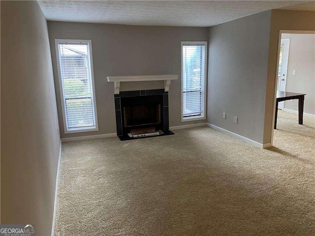 unfurnished living room with carpet flooring and a textured ceiling