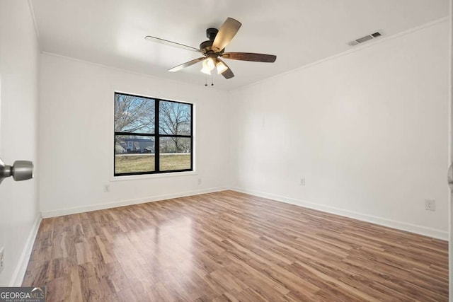 empty room with ceiling fan, hardwood / wood-style floors, and crown molding