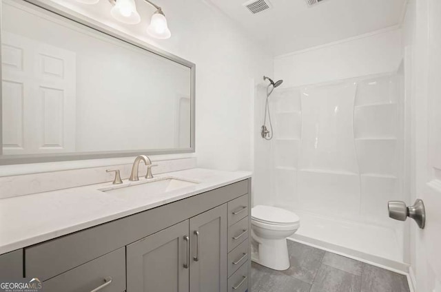 bathroom featuring vanity, toilet, and a shower