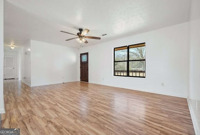 spare room featuring a textured ceiling, light hardwood / wood-style floors, and ceiling fan