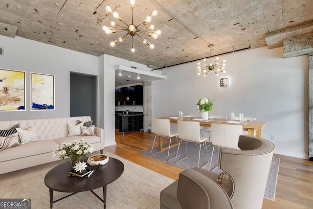 living room featuring light wood-type flooring and an inviting chandelier