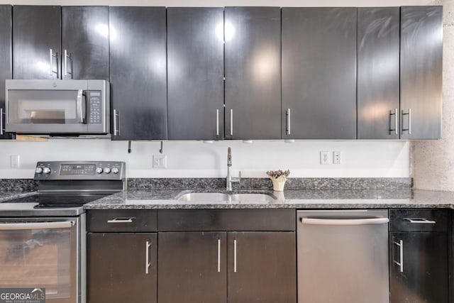 kitchen featuring sink, dark stone countertops, and stainless steel appliances