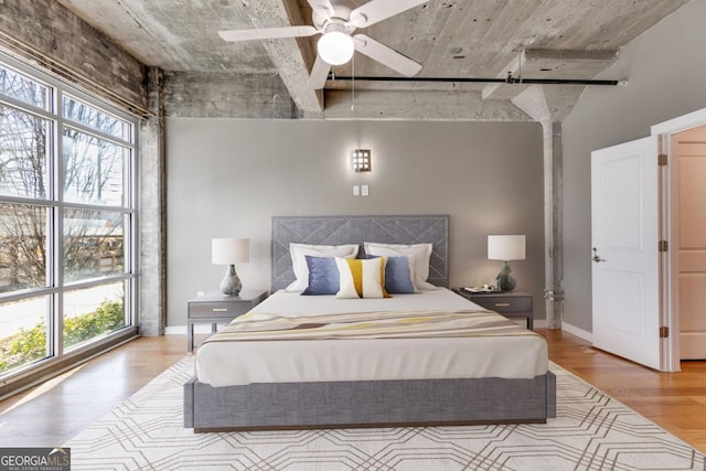 bedroom with ceiling fan, light hardwood / wood-style flooring, and multiple windows