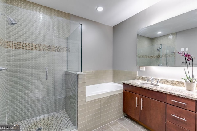 bathroom with tile patterned flooring, vanity, and independent shower and bath