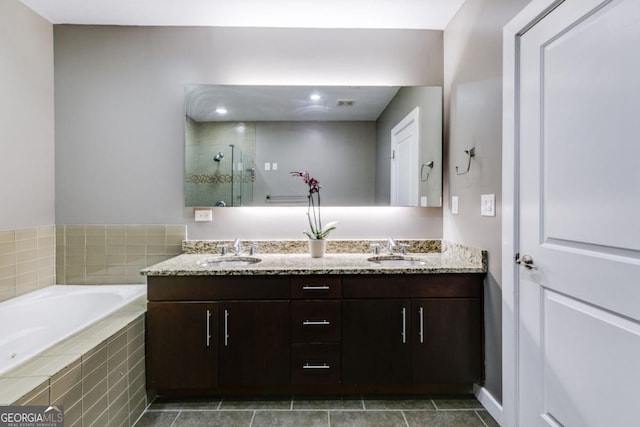 bathroom with vanity and shower with separate bathtub