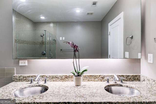 bathroom with vanity and a shower with door