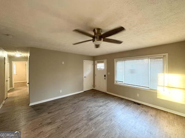 foyer with ceiling fan, dark wood-type flooring, and a textured ceiling