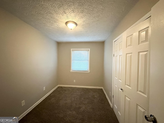 carpeted empty room featuring a textured ceiling