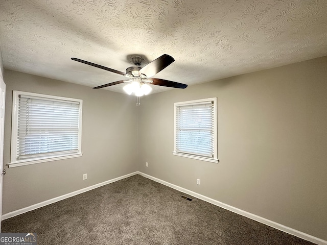 spare room featuring carpet flooring, ceiling fan, and a textured ceiling