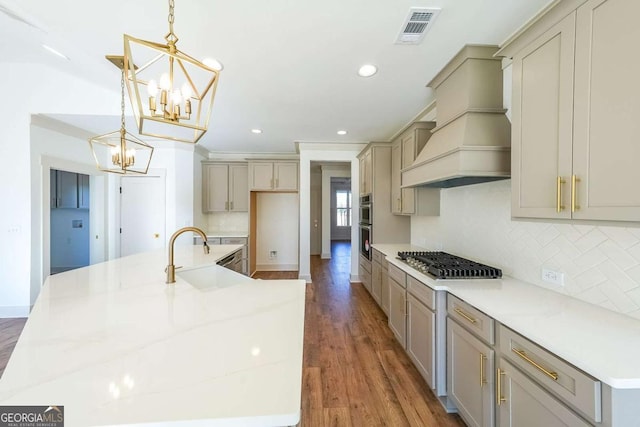 kitchen featuring tasteful backsplash, dark hardwood / wood-style floors, premium range hood, decorative light fixtures, and appliances with stainless steel finishes