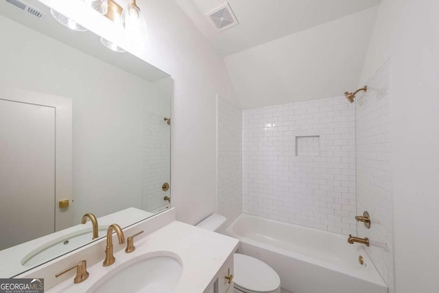 full bathroom featuring vanity, tiled shower / bath, and toilet