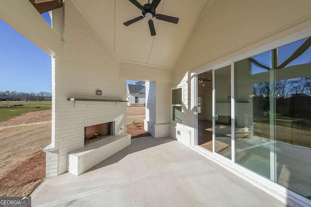 view of patio with ceiling fan and an outdoor brick fireplace