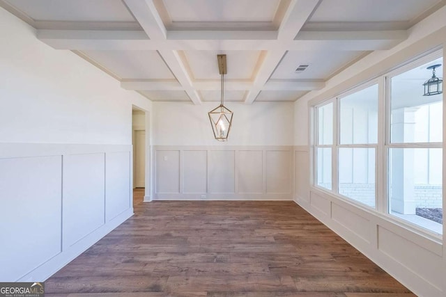 unfurnished dining area with beamed ceiling, dark wood-type flooring, and coffered ceiling